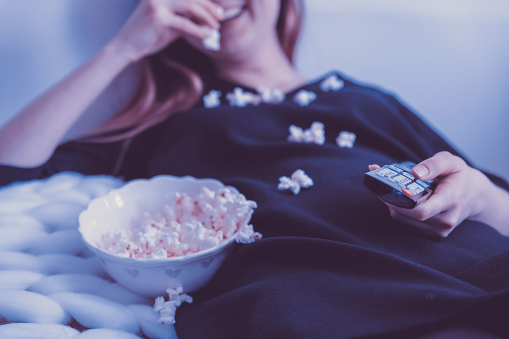 women eating popcorn watching tv